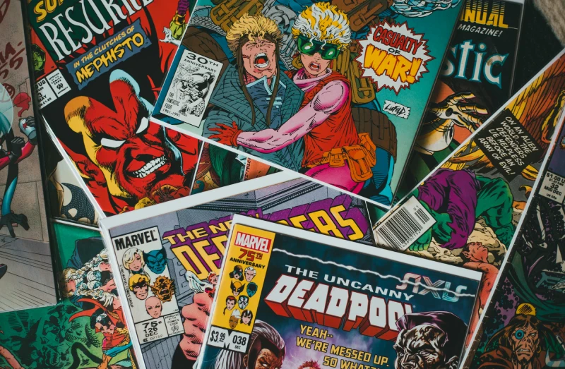 Vintage comic book collection featuring colorful retro superhero covers spread across a table, representing the legacy and evolution of comic publishing culture.